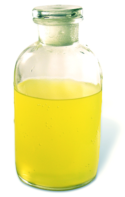Auf dem Bild ist eine transparente Apothekerglasflasche mit Stopfen zu sehen in der sich eine gelbliche Flüssigkeit befindet. 